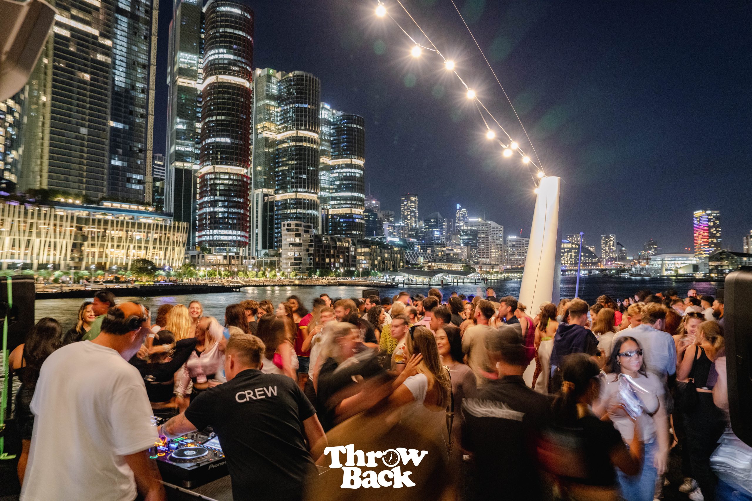 Crowd celebrating at a night-time harbour event