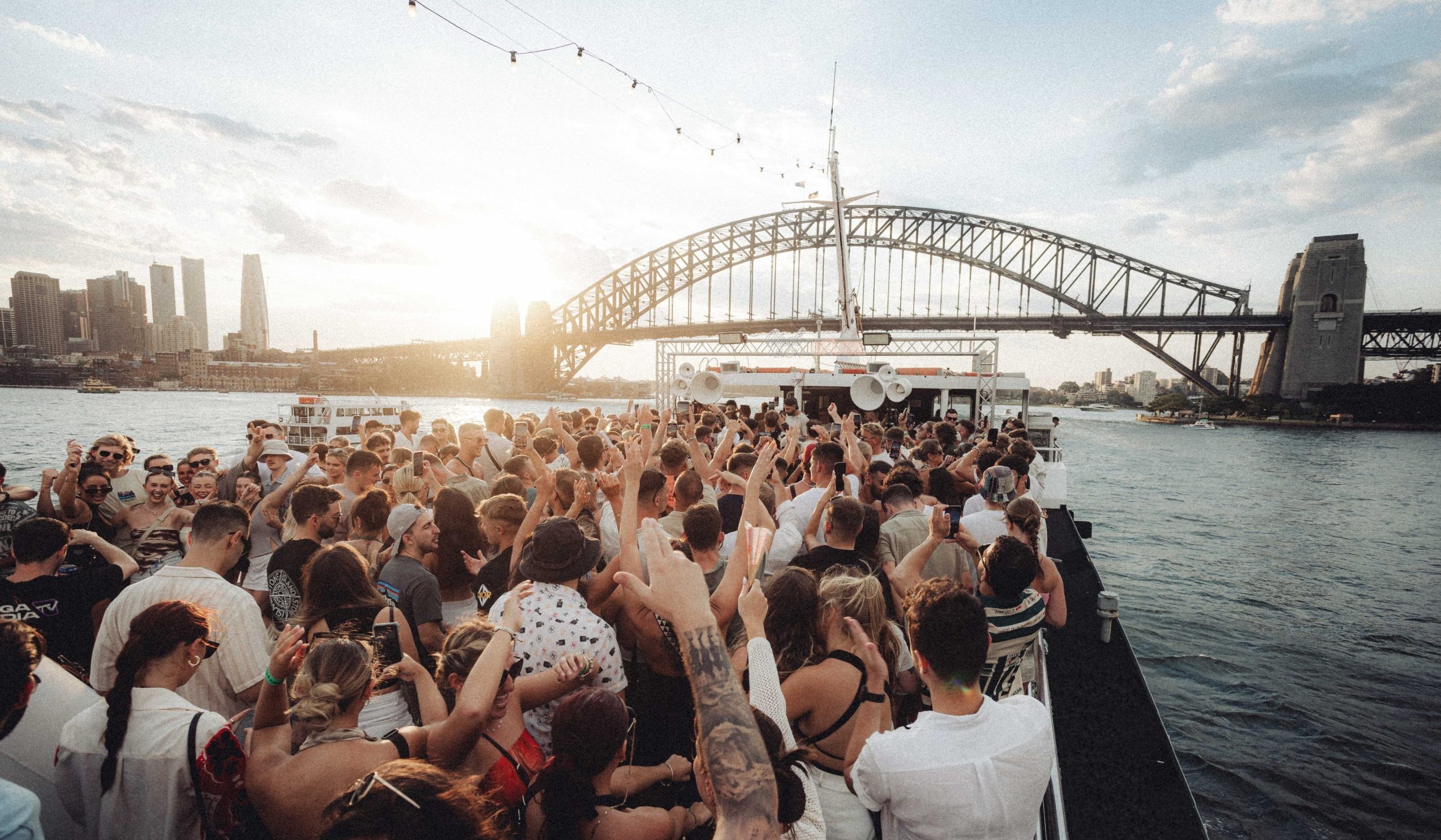 Daytime harbour party crowd beside Sydney Harbour Bridge